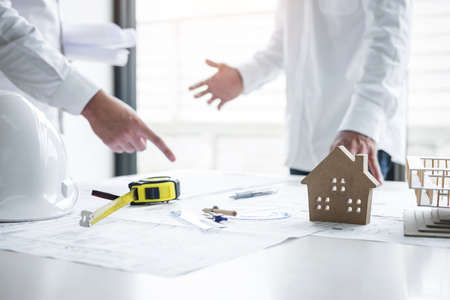 Team of engineering or architect meeting and discussing on blueprint and building model while...