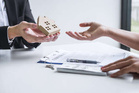 Estate agent sending house model to client after signing agreement contract real estate with approved mortgage application form, concerning mortgage loan offer for and house insurance.の写真素材