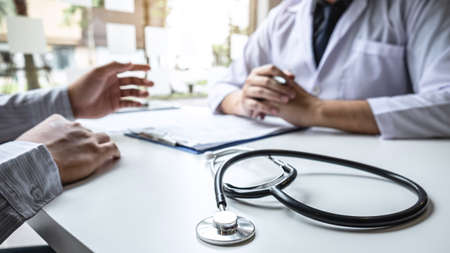 Doctor having conversation with patient while discussing explaining symptoms or counsel diagnosis health and consult treatment of disease, healthcare and assistance concept.の写真素材