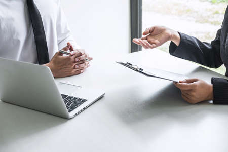 Employer or committee holding reading a resume with talking during about his profile of candidate, employer in suit is conducting a job interview, manager resource employment and recruitment concept.の写真素材