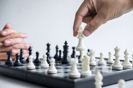 Businessman and businesswoman playing chess and thinking about strategy crash overthrow the opposite team and development analysis for win and successful.の写真素材
