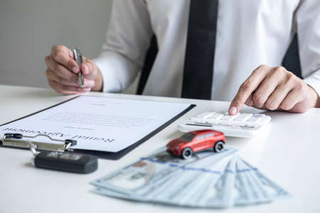 Man client calculating insurance premium for decide signing rental contract form of renting a vehicle agreement, car insurance concept.の写真素材
