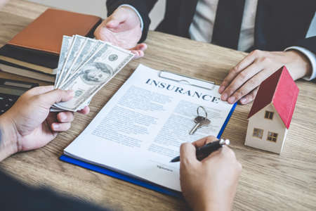Estate agent broker receive money from client after signing agreement contract real estate with approved mortgage application form, buying or concerning mortgage loan offer for and house insurance.の写真素材