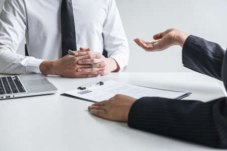 Employer or committee holding reading a resume with talking during about his profile of candidate, employer in suit is conducting a job interview, manager resource employment and recruitment concept.の写真素材