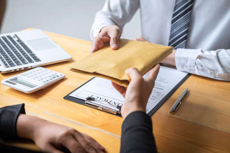 Dishonest cheating in illegal money, Business woman giving bribe money the form of dollar bills to while give success the deal to contract agreement, Bribery and corruption concept.の写真素材
