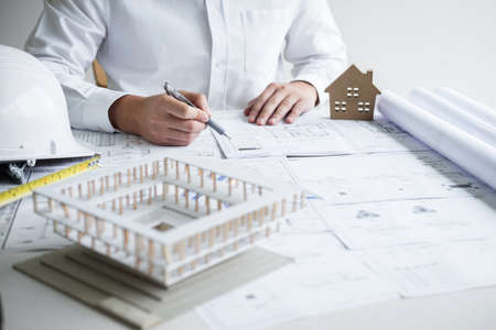 Construction engineering or architect hands working on blueprint inspection in workplace, while checking information drawing and sketching for architecture project working.の写真素材