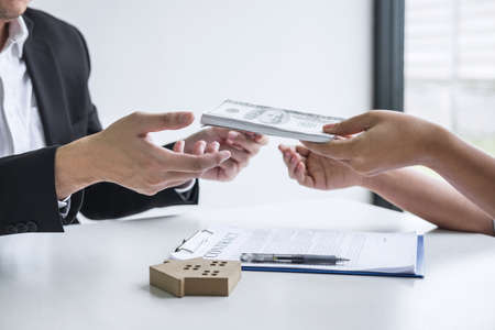 Estate agent broker receive money from client after signing agreement contract real estate with approved mortgage application form, buying or concerning mortgage loan offer for and house insurance.の写真素材