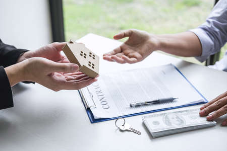 Estate agent sending house model to client after signing agreement contract real estate with approved mortgage application form, concerning mortgage loan offer for and house insurance.の写真素材