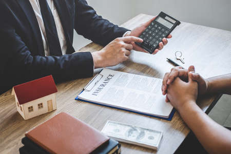 Estate agent broker reach contract form and presentation to client signing agreement contract real estate with approved mortgage application form, buying mortgage loan offer for and house insurance.の写真素材