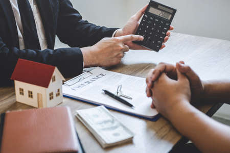 Estate agent broker reach contract form and presentation to client signing agreement contract real estate with approved mortgage application form, buying mortgage loan offer for and house insurance.の写真素材