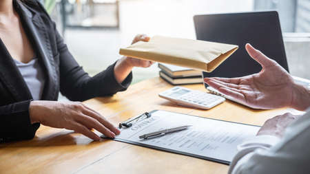 Dishonest cheating in illegal money, Business woman giving bribe money the form of dollar bills to while give success the deal to contract agreement, Bribery and corruption concept.の写真素材