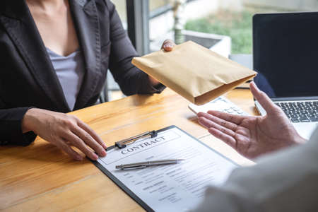 Dishonest cheating in illegal money, Business woman giving bribe money the form of dollar bills to while give success the deal to contract agreement, Bribery and corruption concept.の写真素材