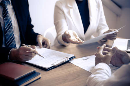 Employer or committee holding reading a resume with talking during about his profile of candidate, employer in suit is conducting a job interview, manager resource employment and recruitment concept.の写真素材