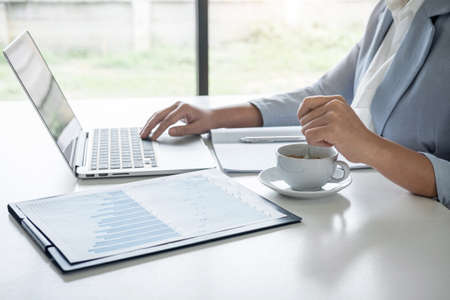 Business woman accountant financier working audit and calculating expense financial annual report balance sheet statement, doing finance checking document and making notes on report paper.の写真素材