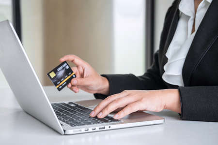 Business woman consumer holding credit card and typing on laptop for online shopping and payment make a purchase on the Internet, Online payment, networking and buy product technology.の写真素材