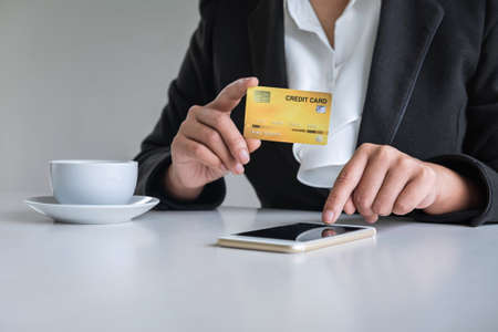 Young woman consumer holding smartphone, credit card and typing for online shopping and payment make a purchase on the Internet, Online payment, networking and buy product technology.の写真素材