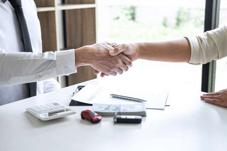 Finishing up of conversation, Realtor agent manager shaking hands with woman client after signing rental form contract agreement, renting considering vehicle car insurance.の写真素材
