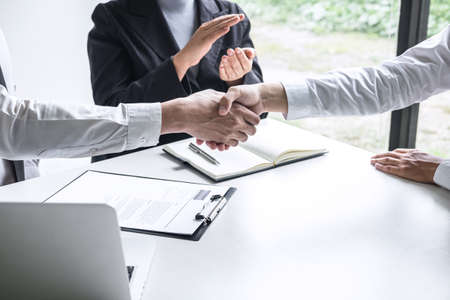 Successful job interview, Image of Boss employer committee or recruiter in suit and new employee shaking hands and clap after good deal negotiation interviewing, career and placement concept.の写真素材