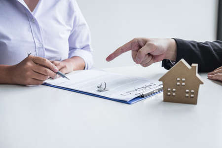 Estate agent broker reach contract form to client signing agreement contract real estate with approved mortgage application form, buying or concerning mortgage loan offer for and house insurance.の写真素材