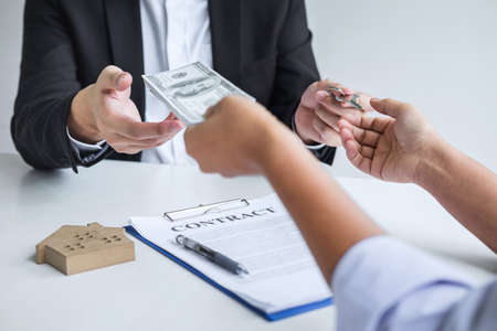 Estate agent broker receive money from client after signing agreement contract real estate with approved mortgage application formの写真素材