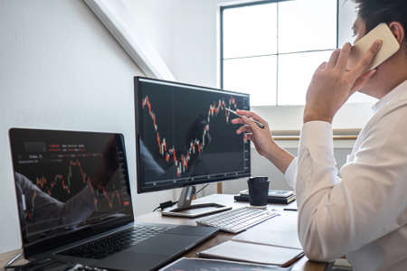 Business investor trading having a planning and analyzing with display screen and pointing on the dataの写真素材