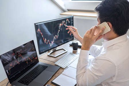 Stock exchange market concept, Business investor trading or stock brokers having a planning and analyzing with display screen and pointing on the data presented and deal on a stock exchange.の写真素材