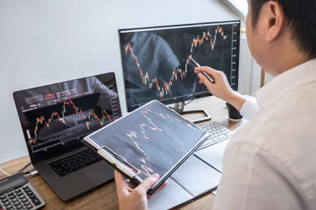 Business investor trading having a planning and analyzing with display screen and pointing on the dataの写真素材