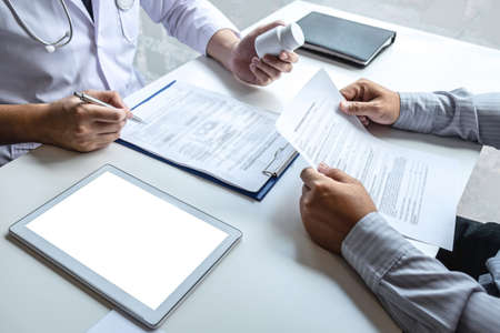 Doctor having conversation with patient while discussing explaining symptoms or counsel diagnosis health and consult treatment of disease, healthcare and assistance concept.の写真素材
