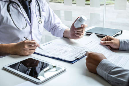 Doctor having conversation with patient while discussing explaining symptoms or counsel diagnosis health and consult treatment of disease, healthcare and assistance concept.の写真素材