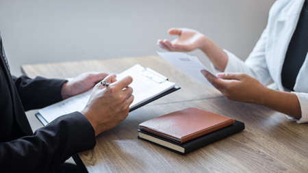 Employer or committee holding reading a resume with talking during about his profile of candidate, employer in suit is conducting a job interview, manager resource employment and recruitment concept.の写真素材