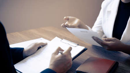 Employer or committee holding reading a resume with talking during about his profile of candidateの写真素材