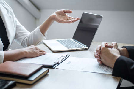 Employer or recruiter holding reading a resume with talking during about his profile of candidate, employer in suit is conducting a job interview, manager resource employment and recruitment concept.の写真素材