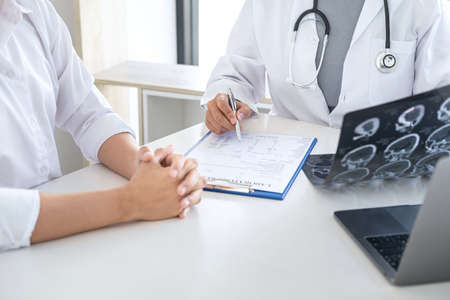 Professor Doctor having conversation with patient and holding x-ray film while discussing explaining symptoms or counsel diagnosis health, healthcare and assistance concept.の写真素材