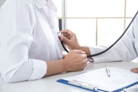 Doctor using a stethoscope checking patient with examining, presenting results symptom and recommend treatment method, Healthcare and medical concept.の写真素材