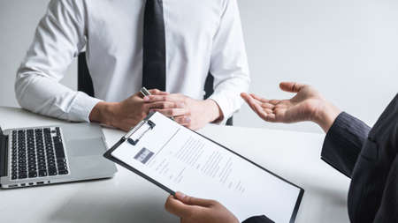 Employer or committee holding reading a resume with talking during about his profile of candidate, employer in suit is conducting a job interview, manager resource employment and recruitment concept.の写真素材