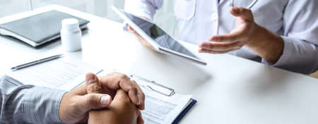 Doctor consulting with patient and checking sickness condition while presenting results diagnosis symptom examining about the problem of illness and recommend treatment method, Healthcare and medical.の写真素材
