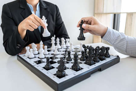 Businessman and businesswoman playing chess and thinking about strategy crash overthrow the opposite team and development analysis for win and successful.の写真素材