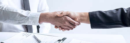 Successful job interview, Boss employer in suit and new employee shaking hands after negotiation and interview, career and placement concept.の写真素材