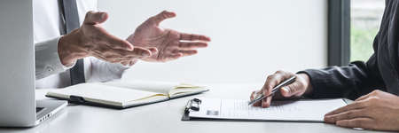 Employer or committee holding reading a resume with talking during about his profile of candidate,...