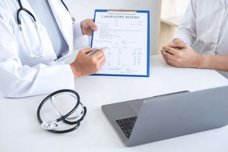 Doctor having conversation with patient while discussing explaining symptoms or counsel diagnosis health and consult treatment of disease, healthcare and assistance concept.の写真素材