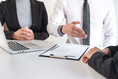 Employer or recruiter holding reading a resume during about colloquy his profile of candidate, employer in suit is conducting a job interview, manager resource employment and recruitment concept.の写真素材