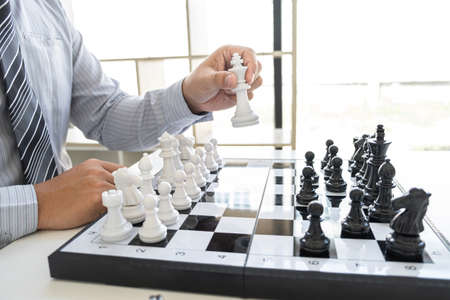 Businessman playing chess and thinking strategy about crash overthrow the opposite team and development analysis for win and successful.の写真素材