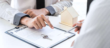 Estate agent broker reach contract form and presentation to client signing agreement contract real estate with approved mortgage application form, buying mortgage loan offer for and house insurance.の写真素材