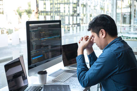 Stressed tired out of work, Development Programmer working in programming website a software and coding technology, writing codes and data code, Programming with HTML, PHP and javascript.の写真素材