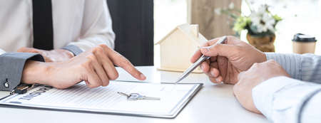 Estate agent broker reach contract form and presentation to client signing agreement contract real estate with approved mortgage application form, buying mortgage loan offer for and house insurance.の写真素材