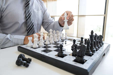 Businessman playing chess and thinking strategy about crash overthrow the opposite team and development analysis for win and successful.の写真素材