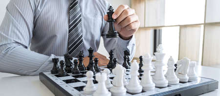 Businessman playing chess and thinking strategy about crash overthrow the opposite team and development analysis for win and successful.の写真素材