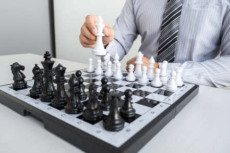 Businessman playing chess and thinking strategy about crash overthrow the opposite team and development analysis for win and successful.の写真素材