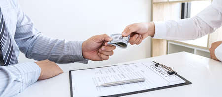 Dishonest cheating in business illegal money, Businessman giving bribe money in business people to accept agreement contract of investment deal, Bribery and corruption concept.の写真素材