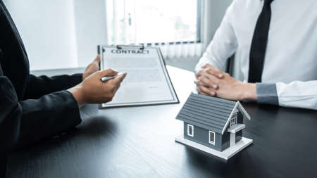 Estate agent broker presentating to client decision signing agreement contract real estate with approved mortgage application, buying mortgage loan offer for and house insurance.の写真素材